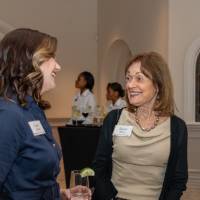 Donna Brook and Laura Aikens chatting with each other at event